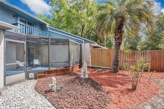 view of yard with a sunroom and fence