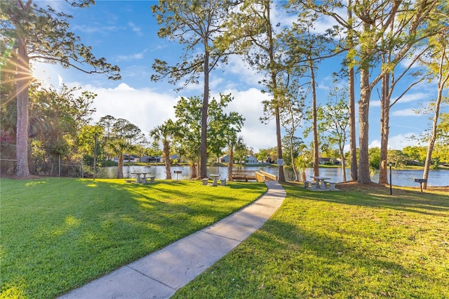 surrounding community with a yard and a water view