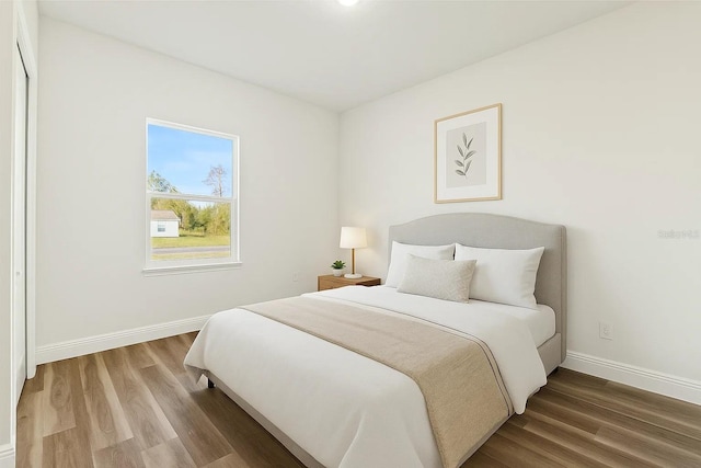bedroom featuring wood finished floors and baseboards