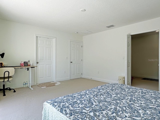 carpeted bedroom with baseboards, visible vents, and a textured ceiling