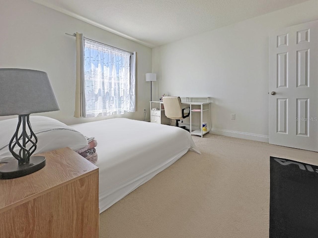 carpeted bedroom featuring baseboards and a textured ceiling