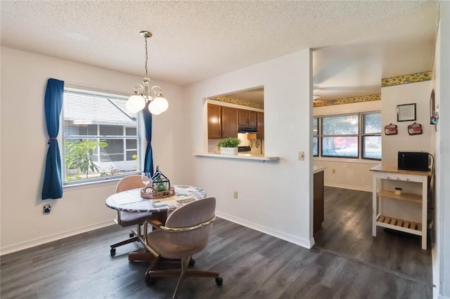 1148 Monroe Ave, Saint Cloud, FL 34769 - dining area with dark wood-style floors, a textured ceiling, plenty of natural light, a chandelier, and baseboards