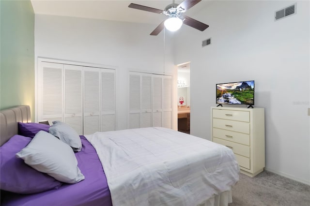 1148 Monroe Ave, Saint Cloud, FL 34769 - bedroom with light carpet, high vaulted ceiling, ceiling fan, two closets, and baseboards