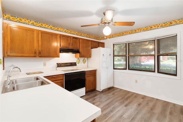 1148 Monroe Ave, Saint Cloud, FL 34769 - kitchen with range with electric cooktop, a sink, under cabinet range hood, white fridge with ice dispenser, and light countertops