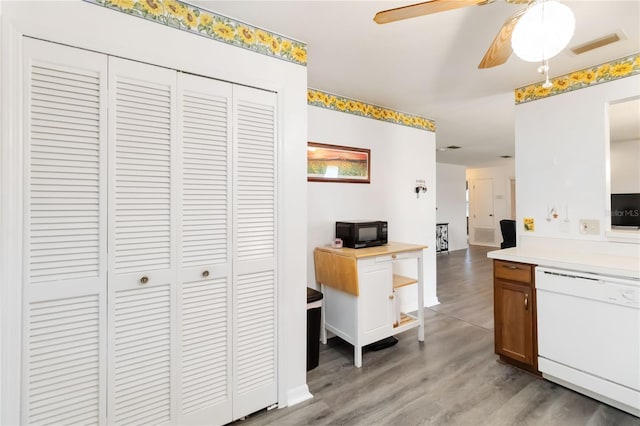 1148 Monroe Ave, Saint Cloud, FL 34769 - kitchen with white dishwasher, black microwave, light wood finished floors, light countertops, and ceiling fan
