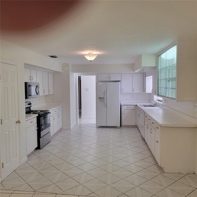 1661 Votaw Rd, Apopka, FL 32703 - kitchen with a sink, light countertops, black electric range, white refrigerator with ice dispenser, and stainless steel microwave