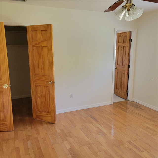 1661 Votaw Rd, Apopka, FL 32703 - unfurnished bedroom featuring ceiling fan, baseboards, a walk in closet, and light wood-style floors