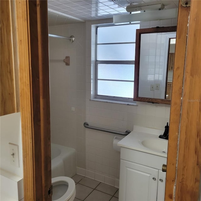 1661 Votaw Rd, Apopka, FL 32703 - bathroom with vanity, washtub / shower combination, tile patterned flooring, tile walls, and toilet