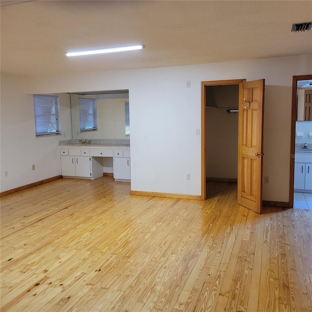1661 Votaw Rd, Apopka, FL 32703 - interior space featuring light wood-type flooring, visible vents, a sink, built in desk, and baseboards