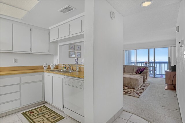 2465 S Washington Ave Unit A402, Titusville, FL 32780 - kitchen featuring visible vents, a sink, light countertops, light colored carpet, and dishwasher