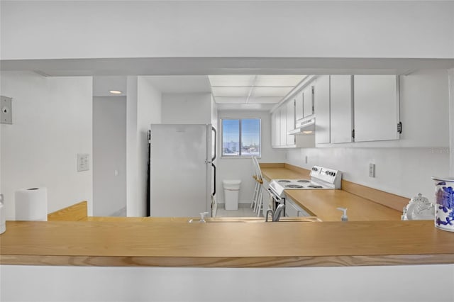 2465 S Washington Ave Unit A402, Titusville, FL 32780 - kitchen with white cabinetry, white appliances, light countertops, and under cabinet range hood