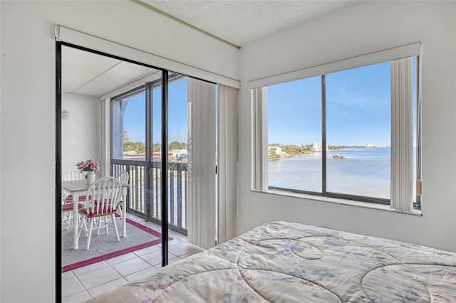 2465 S Washington Ave Unit A402, Titusville, FL 32780 - tiled bedroom with access to outside, multiple windows, a water view, and a textured ceiling
