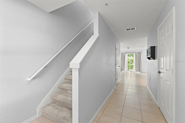 435 Tradition Ln, Winter Springs, FL 32708 - stairway with tile patterned floors, visible vents, baseboards, and a textured ceiling