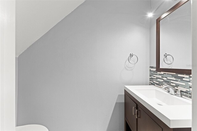 435 Tradition Ln, Winter Springs, FL 32708 - half bathroom featuring toilet, vanity, and tasteful backsplash