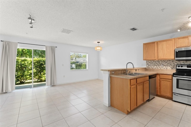 435 Tradition Ln, Winter Springs, FL 32708 - kitchen featuring tasteful backsplash, stainless steel appliances, a sink, visible vents, and a peninsula