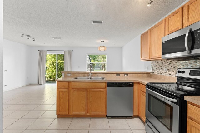 435 Tradition Ln, Winter Springs, FL 32708 - kitchen with light tile patterned flooring, visible vents, a peninsula, appliances with stainless steel finishes, and a sink