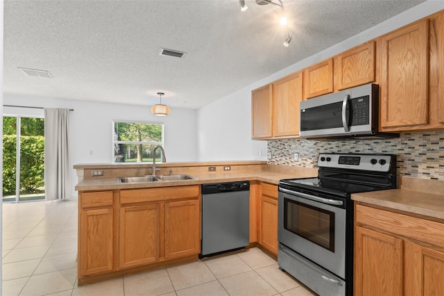 435 Tradition Ln, Winter Springs, FL 32708 - kitchen with tasteful backsplash, a sink, visible vents, a peninsula, and appliances with stainless steel finishes