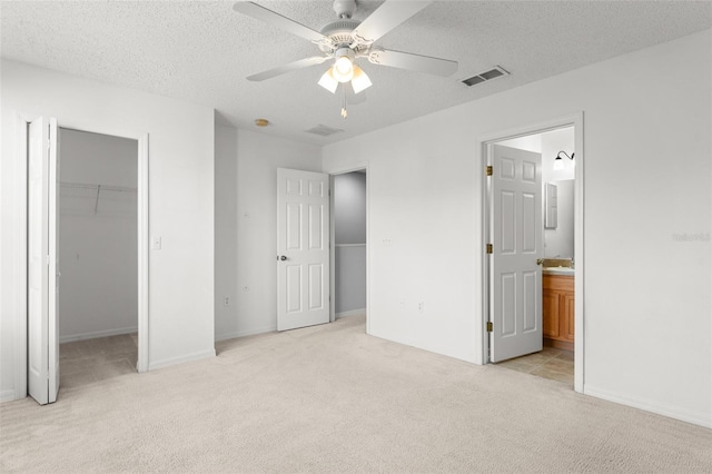 435 Tradition Ln, Winter Springs, FL 32708 - unfurnished bedroom with a closet, light carpet, a spacious closet, a textured ceiling, and visible vents