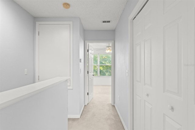 435 Tradition Ln, Winter Springs, FL 32708 - hall with baseboards, a textured ceiling, visible vents, and light colored carpet