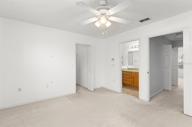 435 Tradition Ln, Winter Springs, FL 32708 - unfurnished bedroom with a walk in closet, light colored carpet, baseboards, ensuite bath, and visible vents