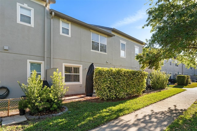 435 Tradition Ln, Winter Springs, FL 32708 - view of home's exterior with stucco siding, fence, and a yard