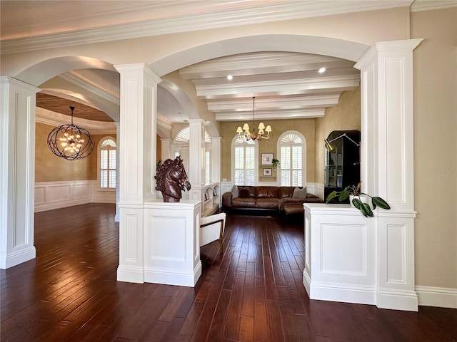 1570 Oakford Rd, Sarasota, FL 34240 - living room featuring a chandelier, dark wood-type flooring, arched walkways, wainscoting, and a decorative wall