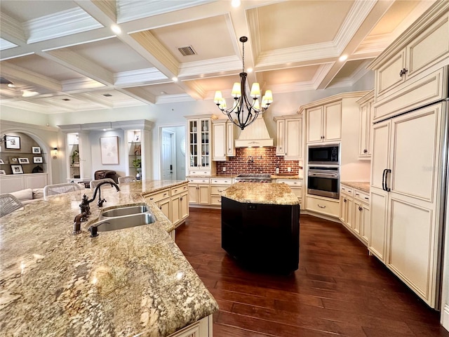 1570 Oakford Rd, Sarasota, FL 34240 - kitchen with built in appliances, cream cabinetry, a large island, a sink, and a chandelier