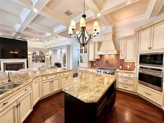 1570 Oakford Rd, Sarasota, FL 34240 - kitchen with stainless steel appliances, cream cabinets, open floor plan, coffered ceiling, and beamed ceiling