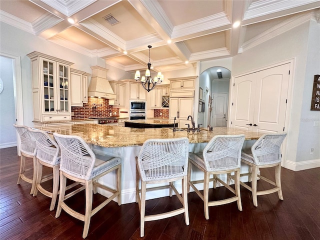 1570 Oakford Rd, Sarasota, FL 34240 - kitchen featuring built in microwave, cream cabinets, oven, a sink, and arched walkways