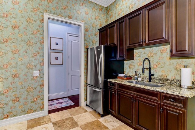 1570 Oakford Rd, Sarasota, FL 34240 - kitchen with a sink, freestanding refrigerator, baseboards, light stone countertops, and dark brown cabinetry