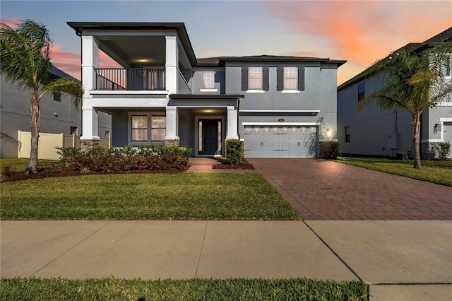3121 Buffington Pl, Oviedo, FL 32765 - view of front of home with a balcony, stucco siding, decorative driveway, an attached garage, and a front yard