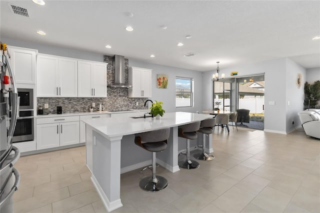3121 Buffington Pl, Oviedo, FL 32765 - kitchen with wall chimney exhaust hood, a sink, stainless steel oven, decorative backsplash, and a kitchen island with sink