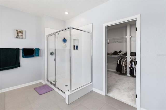 3121 Buffington Pl, Oviedo, FL 32765 - bathroom featuring a stall shower, a spacious closet, baseboards, and tile patterned flooring