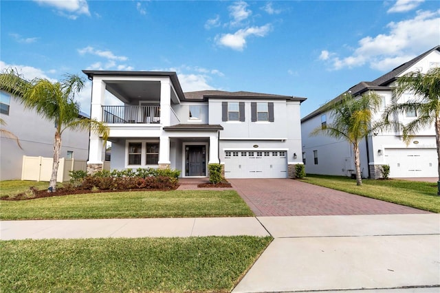 3121 Buffington Pl, Oviedo, FL 32765 - view of front of home with a balcony, stucco siding, decorative driveway, an attached garage, and stone siding