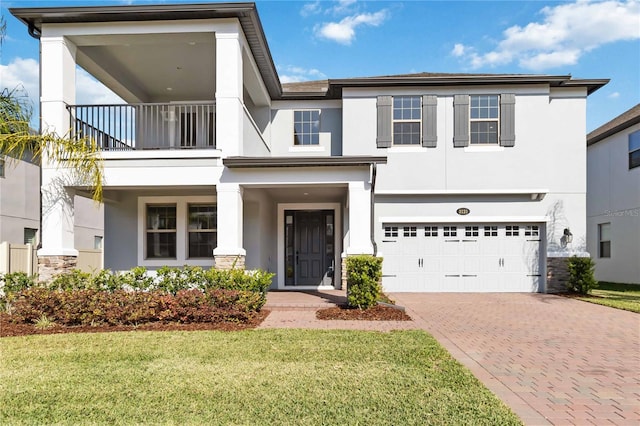 3121 Buffington Pl, Oviedo, FL 32765 - view of front of house with a balcony, stucco siding, decorative driveway, an attached garage, and stone siding