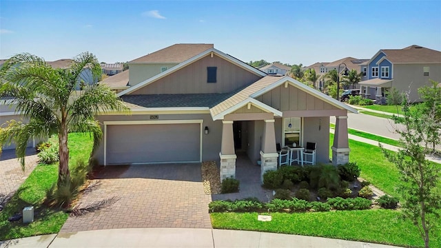 5052 Blanchard Ct, Saint Cloud, FL 34772 - view of front of home featuring roof with shingles, a porch, stucco siding, a garage, and decorative driveway