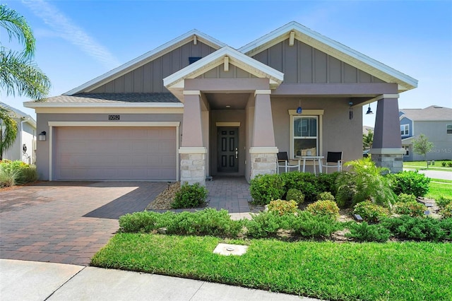 5052 Blanchard Ct, Saint Cloud, FL 34772 - craftsman house featuring driveway, covered porch, stucco siding, a garage, and board and batten siding