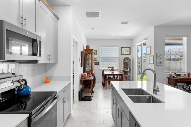 5052 Blanchard Ct, Saint Cloud, FL 34772 - kitchen featuring visible vents, backsplash, light countertops, stainless steel appliances, and a sink