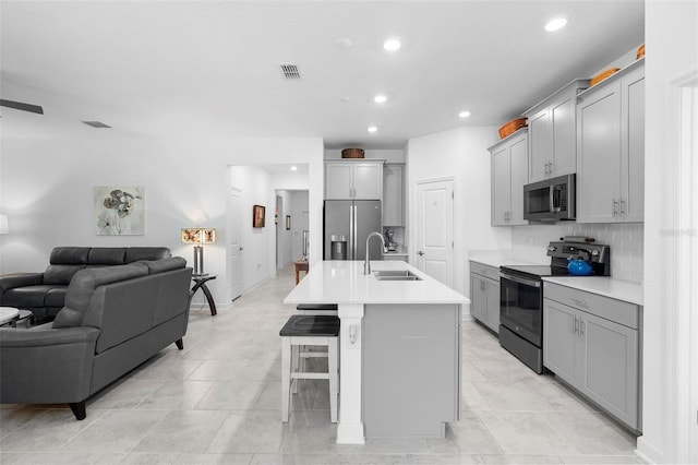 5052 Blanchard Ct, Saint Cloud, FL 34772 - kitchen with visible vents, gray cabinetry, a sink, open floor plan, and stainless steel appliances