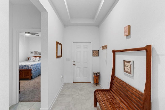 5052 Blanchard Ct, Saint Cloud, FL 34772 - hallway with light colored carpet, a tray ceiling, and baseboards
