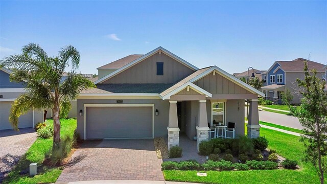 5052 Blanchard Ct, Saint Cloud, FL 34772 - view of front facade with stucco siding, decorative driveway, a porch, a shingled roof, and a garage
