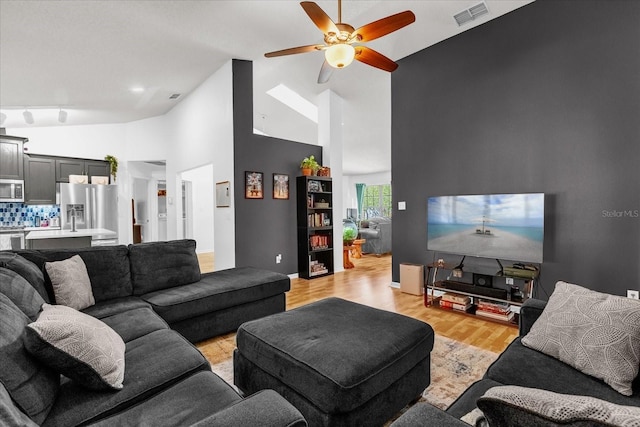 10400 Hunters Trail Ct, Orlando, FL 32817 - living area with light wood finished floors, visible vents, baseboards, high vaulted ceiling, and a ceiling fan