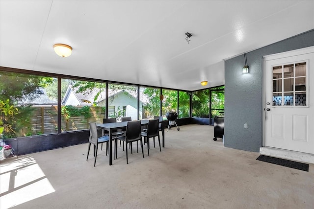10400 Hunters Trail Ct, Orlando, FL 32817 - sunroom with unfinished concrete flooring, outdoor dining area, and a textured wall