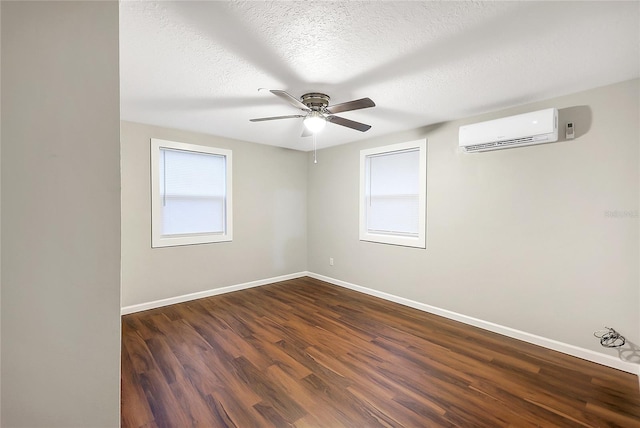 626 Marvin C Zanders Ave, Apopka, FL 32703 - empty room with dark wood-style floors, a ceiling fan, baseboards, a wall mounted AC, and a textured ceiling