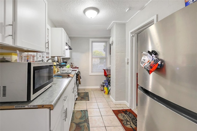 626 Marvin C Zanders Ave, Apopka, FL 32703 - kitchen featuring under cabinet range hood, a textured ceiling, stainless steel appliances, white cabinets, and light tile patterned floors