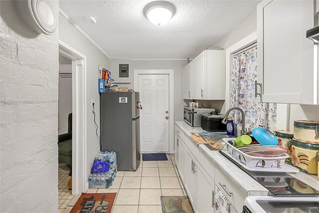 626 Marvin C Zanders Ave, Apopka, FL 32703 - kitchen with freestanding refrigerator, a sink, light countertops, white cabinets, and a textured ceiling