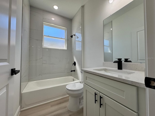 full bath featuring tub / shower combination, toilet, vanity, and wood finished floors