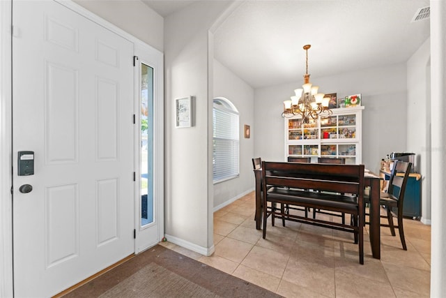 foyer entrance featuring light tile patterned flooring, baseboards, visible vents, and an inviting chandelier