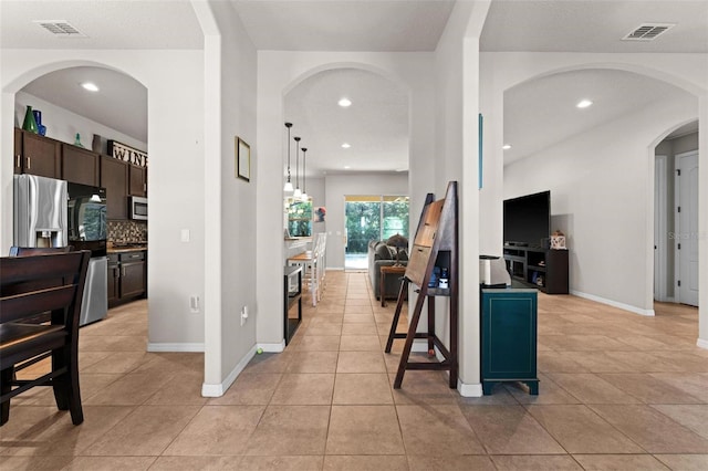 interior space featuring light tile patterned flooring, visible vents, and recessed lighting