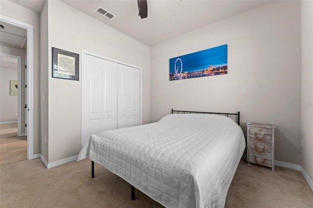 bedroom with baseboards, visible vents, a ceiling fan, light carpet, and a closet
